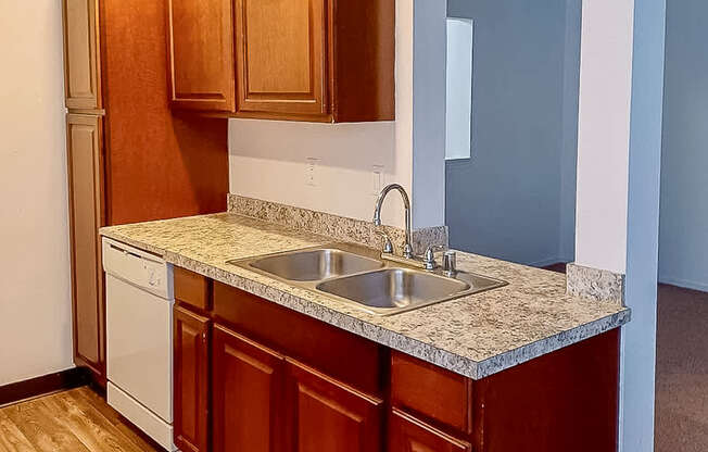 A kitchen with wooden cabinets and a white dishwasher.