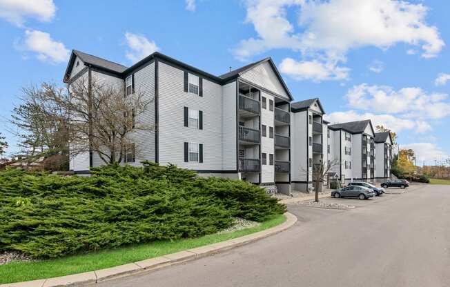 Apartment building with a parking lot in front.
