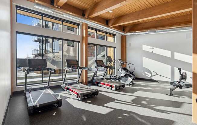 A gym with treadmills, elliptical machines and other exercise equipment.