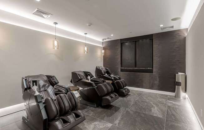 A row of black leather chairs are lined up in a room.