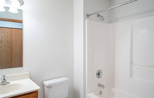 a bathroom with a toilet and a sink and a shower.  Eagan, MN Glen Pond Apartments