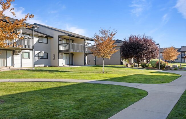Exterior apartments with balconies and sidewalks through the bright green grass and well-maintained landscaping. at Brix, Walla Walla, WA, 99362