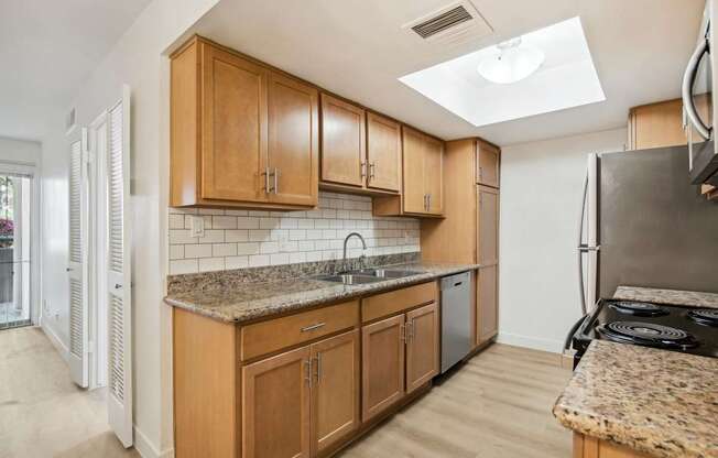 A kitchen with wooden cabinets and a granite countertop.