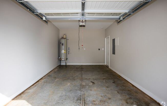 the inside of a garage with a concrete floor and white walls