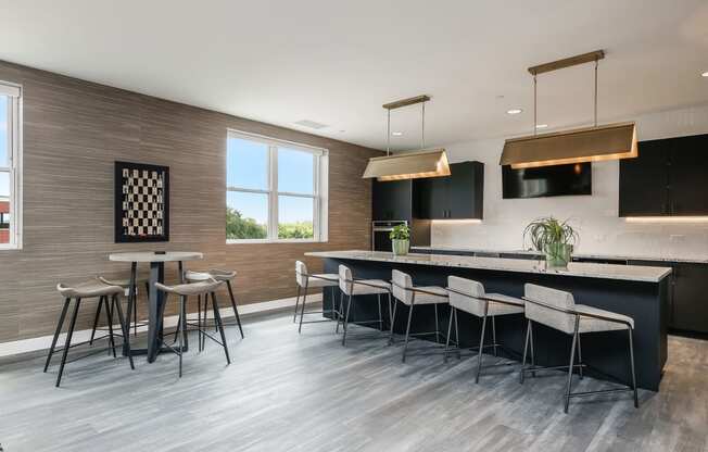 a kitchen with a bar and chairs and a table with stools