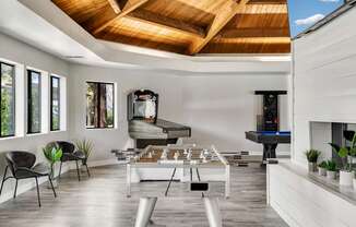 A modern living room with a pool table and a fireplace.