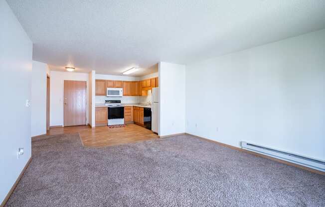 A living room with a kitchen in the background. Fargo, ND Stonebridge Apartments