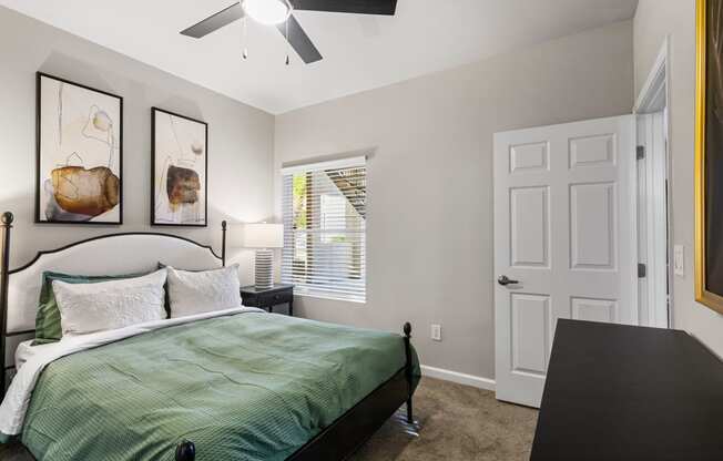 a bedroom with a bed and a ceiling fan