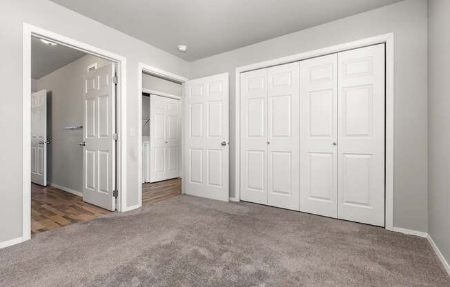 A room with white doors and a carpeted floor.