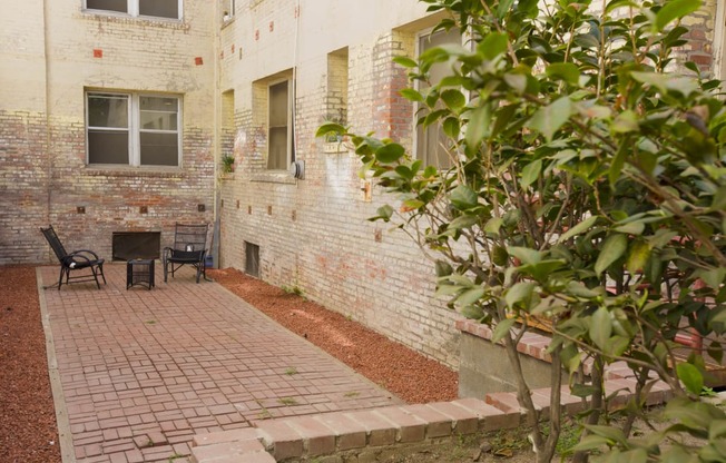 the outside of a brick building with a patio and a chair at Del Mor, Los Angeles, CA, 90026