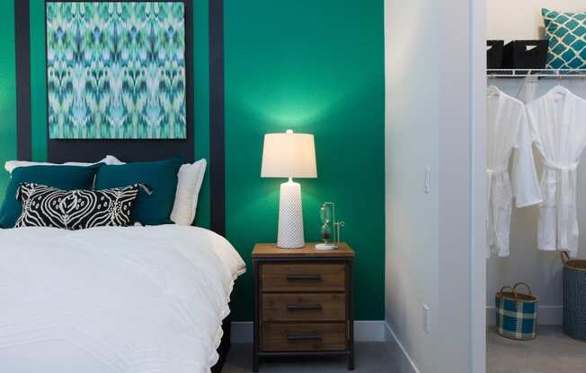a bedroom with a green accent wall and white bedding