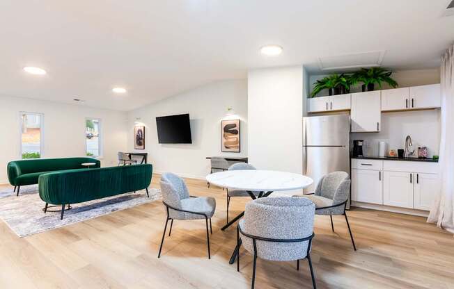 A modern living room with a green sofa and grey chairs.