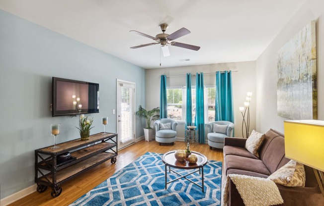 a living room with blue walls and a ceiling fan