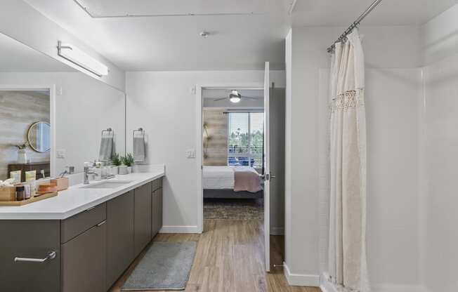 Bathroom with a shower and a bed in the background at Array La Mesa, La Mesa, CA