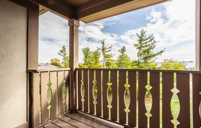 a balcony with a view of a blue sky and trees