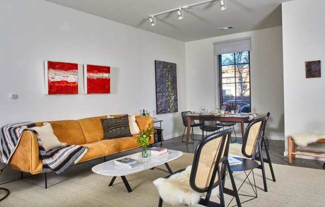 a living room with a couch and chairs and a dining room table