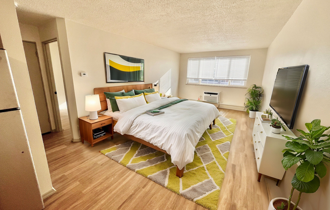 Experience luxury and comfort in this stylish bedroom with vibrant decor and natural light.