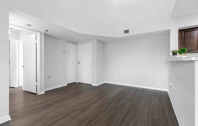 A room with wooden flooring and white walls.