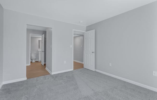 a living room with a carpet and a door to a bathroom