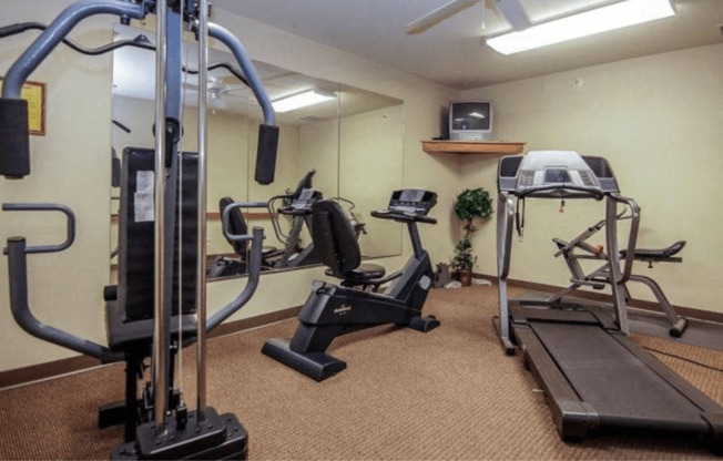 a gym with exercise equipment and a mirror