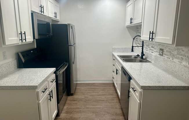 a kitchen with white cabinets and a sink and a refrigerator