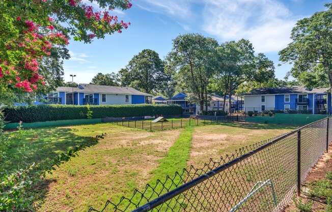 a fenced in yard with houses in the background