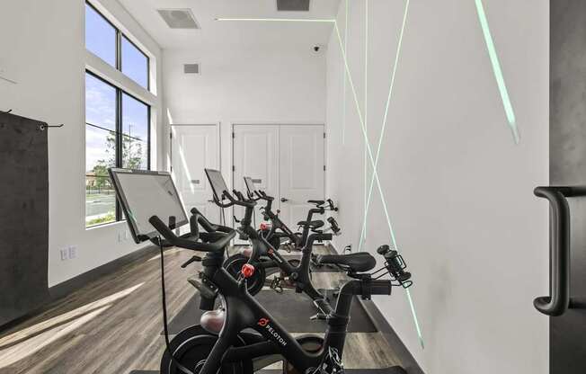 A bike is parked in a room with a white wall and a window.