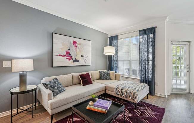 A living room with a couch, a table, and a painting on the wall.