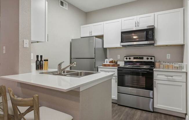 A kitchen with white cabinets and stainless steel appliances.