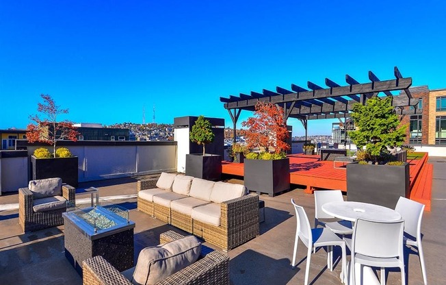 a roof top patio with furniture and a pergola