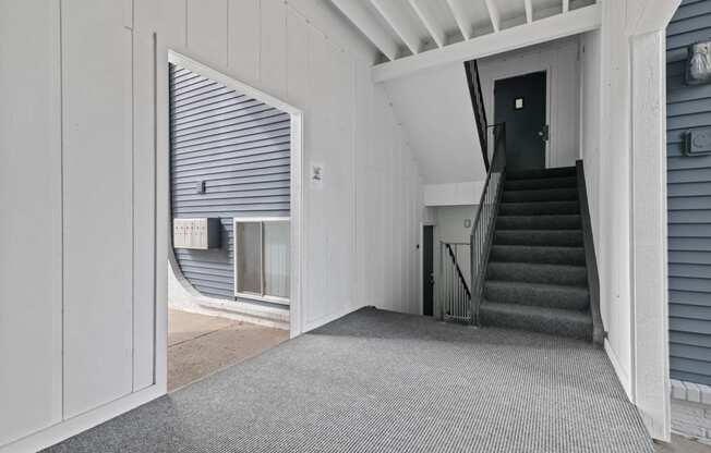 the entrance to a white house with a staircase and a door