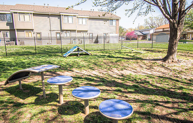 A playground with a blue table and a slide in the background.