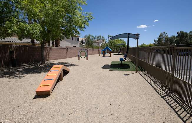 Large pet park with gravel run, agility equipment and covered seating.