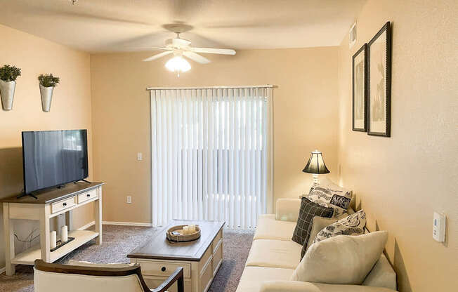 A living room with a television, a couch, and a coffee table.