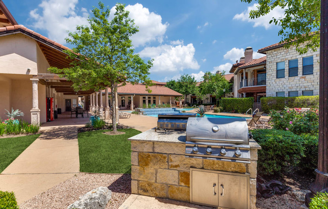 a barbecue grill in the backyard of a house with a swimming pool