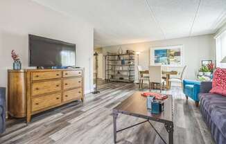 A living room with a wooden dresser and a television on top of it.