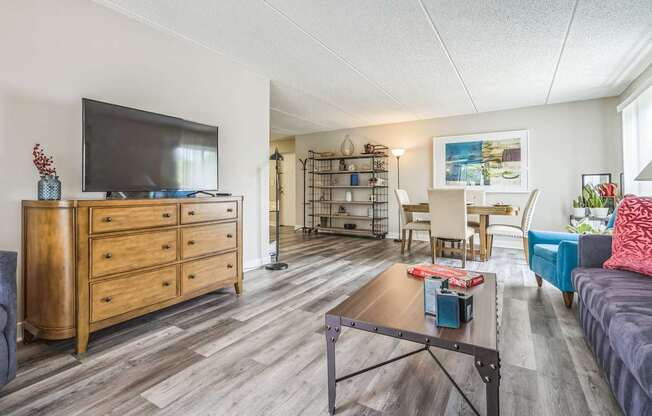 A living room with a wooden dresser and a television on top of it.