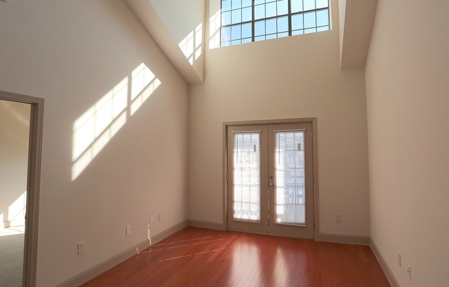 an empty room with two windows and a door
