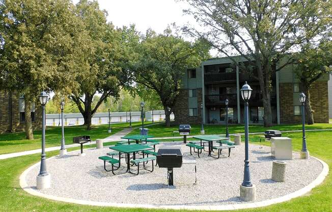 a park with picnic tables in front of a building