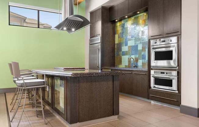 A modern kitchen with a green wall and a wooden island.