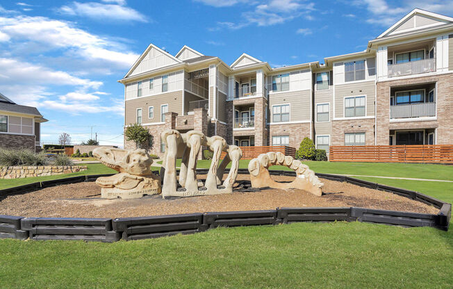 playground shaped like a dinosaur skeleton in front of an apartment building