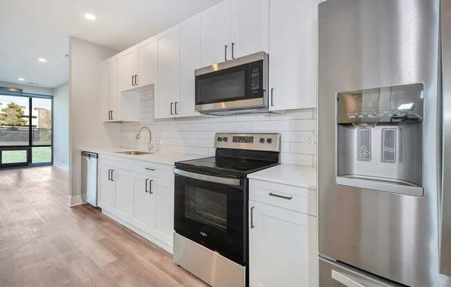 a kitchen with white cabinets and a stove and a microwave
