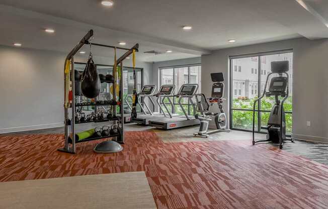 A gym with a red floor and various exercise equipment.