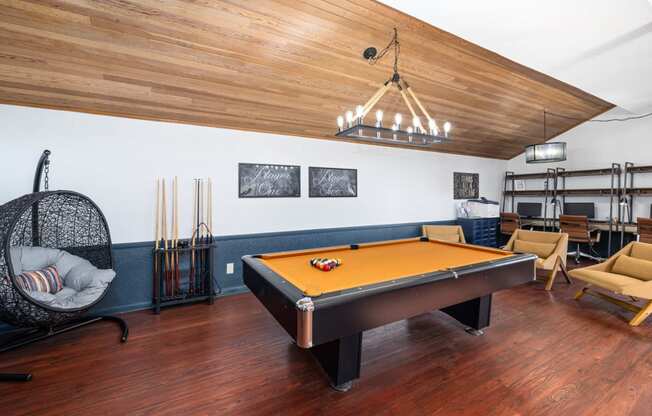 a game room with a pool table and a chandelier