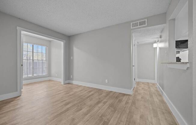A room with wooden flooring and white walls.