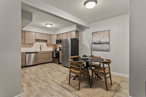 a kitchen and dining area with stainless steel appliances and a table and chairs