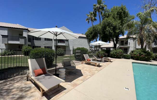 Dive into relaxation in our backyard paradise. Enjoy poolside comfort with chic chairs and shady umbrellas at Boulders at Lookout Mountain Apartment Homes, Arizona