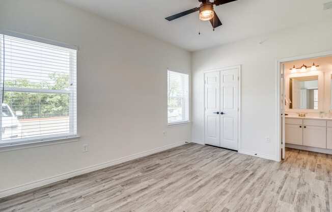 an empty living room with a ceiling fan and a window