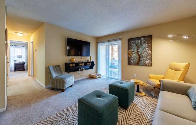 a living room with a couch and chairs and a tv