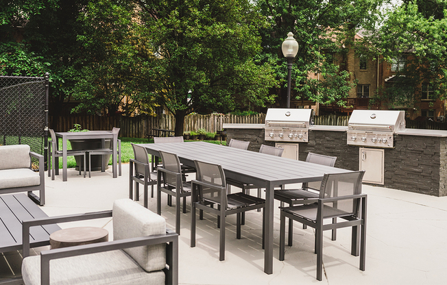 Upgraded outdoor kitchen features state of the art grills, community table and plenty of lounge seating